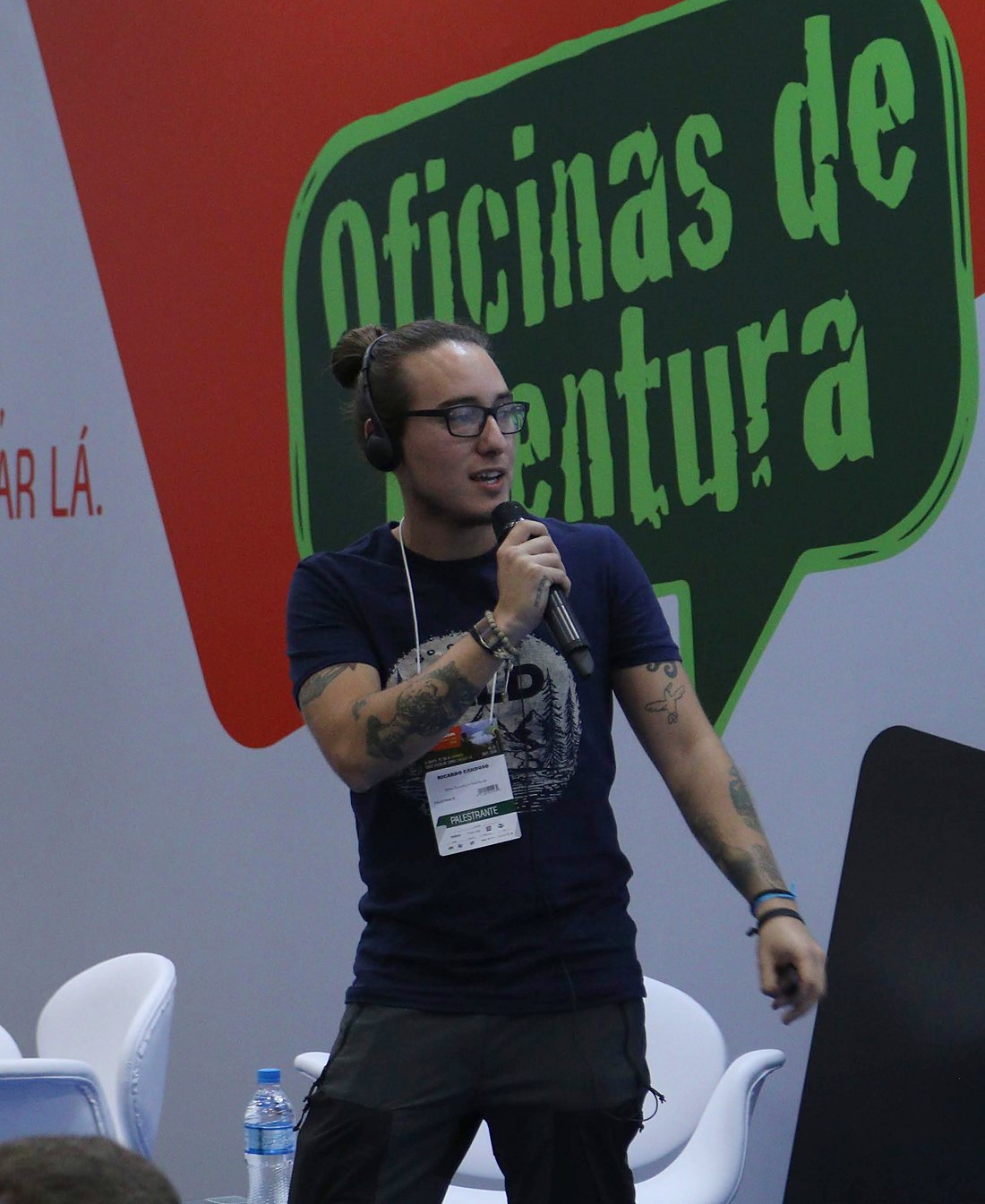 Ricardo Cardoso palestrando com microfone no palco das Oficinas de Aventura, na Adventure Sports Fair