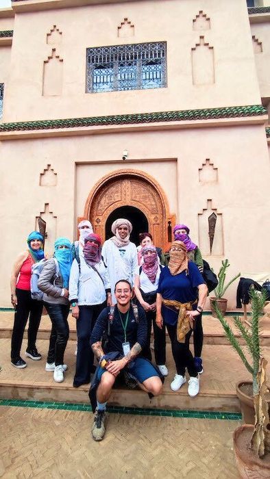 Grupo com lenços diante de uma porta tradicional no Marrocos
